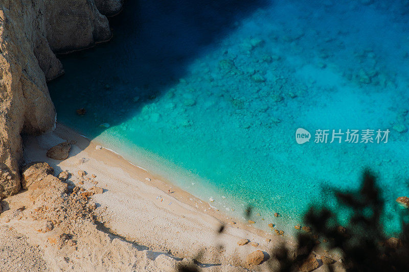 在扎金索斯岛(Zakynthos island)，人们在水晶蓝色的大海中隐蔽的海滩上放松的鸟瞰图